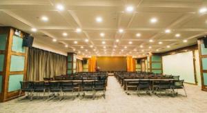 a large room with tables and chairs and a screen at Lavande Hotel Yichang Railway East Station Branch in Yichang