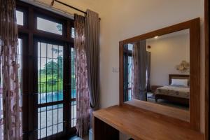 a mirror in a room with a bed and a window at Sandila Villa in Matara +42 photos