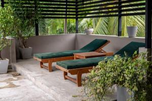 two benches with green cushions sitting on a patio at Sandila Villa in Matara