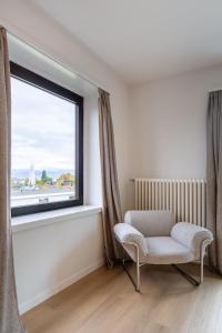 Chocolate Suite - free parking في Kilchberg: غرفة معيشة مع كرسي ونافذة