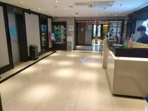 a lobby of a shopping mall with a man at a counter at Xana Hotelle Jinan Daminghu North Gate in Jinan
