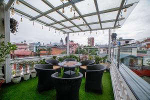 Un patio con una mesa y sillas en un balcón. en Victorian Venue Hotel, en Katmandú 4 fotos más