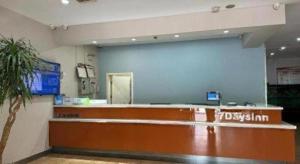 Una sala de espera con una gran pared azul en una tienda. en 7 Days Inn Tianjin South Railway Station, en Tianjin