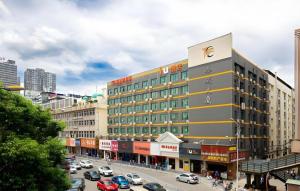 a large building on a busy city street with cars at IU Hotel Changsha Railway Station Branch in Changsha