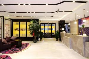 a lobby with a couch and some plants at Lavande Hotels·Qingdao Wusi Square in Qingdao