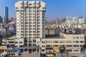 a tall white building in front of a city at Lavande Hotels·Qingdao Wusi Square in Qingdao