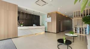 徐州市にあるJinjiang Inn Select Xuzhou High-speed Railway Station Kunpeng Roadの建物内のテーブルと椅子のあるロビー