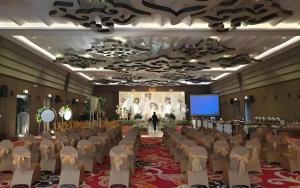 a room with a bunch of chairs and a screen at Patra Cirebon Hotel & Convention in Plered