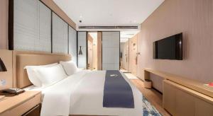 済南市にあるEcharm Hotel Jinan West Station International Exhibition Centerの大きな白いベッドとテレビのある寝室 +212枚の写真