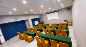 済南市にあるEcharm Hotel Jinan West Station International Exhibition Centerの緑と黄色のテーブルと椅子のある部屋