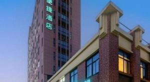 a tall building with a clock on the side of it at City Comfort Inn Shanghai International Automobile City Tongji University in Anting Zhan