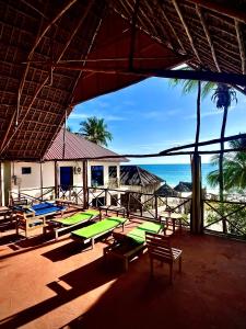a group of picnic tables with the ocean in the background at Zanzibar beach escape 1&2 in Bwejuu