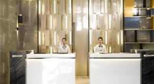 two men are standing behind counter in a restaurant at Echarm Hotel Nanning the MixC Exhibition Center Metro Station in Nanning