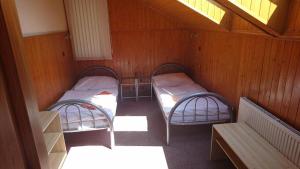 a room with two beds and a bench in it at Penzion U Zvonku in Litvínov