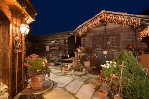 an outside view of a wooden house with potted plants at Hotel Romantica in Zermatt