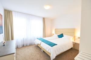 ブレーマーハーフェンにあるNordsee Apartmentsのベッドルーム1室(ベッド1台、大きな窓付)