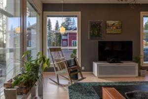 Una sala de estar con un televisor y una silla. en Villa Mäntykumpu by Hi Ylläs, en Ylläsjärvi