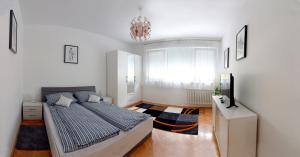 um quarto com uma cama e um lustre em Apartmani Vedmar em Zagreb