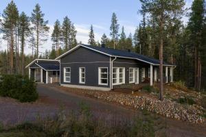 una casa negra en medio de un bosque en Villa Mäntykumpu by Hi Ylläs, en Ylläsjärvi