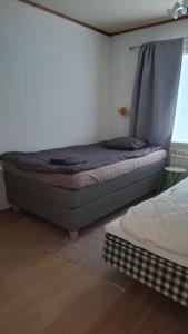 un dormitorio con una cama y una ventana en Omakotitalo, en Sodankylä