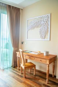 a wooden desk with a chair next to a window at Vannee Golden Sands Beachfront Resort in Haad Rin