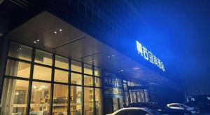 a building with cars parked in front of it at Echarm Hotel Huangshi Yingbin Avenue in Huangshigang