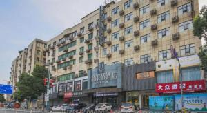 un grand bâtiment avec des voitures garées devant dans l'établissement UP and IN Hotel Jiangxi Nanchang City Nanchang County Liantang Zhong Avenue Huarunwanjia, à Nanchang County