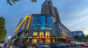 a large building with cars parked in front of it at James Joyce Coffetel Shijiazhuang the Mixc Jinyuan Tower Airport Bus in Shijiazhuang