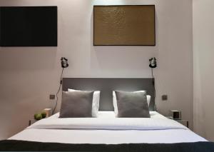 a bed with a white comforter and white pillows at Centric Gracia Apartments in Barcelona