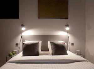 a bed with a white comforter and pillows at Centric Gracia Apartments in Barcelona
