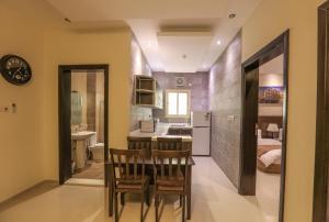 a kitchen and dining room with a table and chairs at Al Itqan For Serviced Apartments-الاتقان للشقق المخدومة in Jeddah