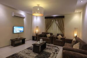 a living room with a couch and a tv at Al Itqan For Serviced Apartments-الاتقان للشقق المخدومة in Jeddah