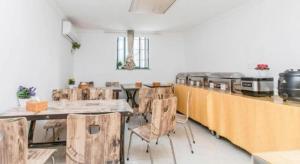 Cette chambre dispose de tables et de chaises en bois ainsi que d'une cuisine. dans l'établissement City Comfort Inn Nanchang Bayi Square Metro Station Wushang, à Nanchang