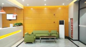 a waiting room with two green chairs and a table at Shell Hotel Liaocheng Dongchang Xi Road Railway Station in Liaocheng