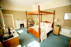 a bedroom with a four poster bed and a fireplace at Dufferin Coaching Inn in Killyleagh +56 photos