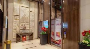 un hall d'entrée avec un bureau et des fleurs dans un immeuble dans l'établissement VX Hotel Wuxi Xinwu District Executive Center Wanda Plaza, à Wuxi 86 autres photos