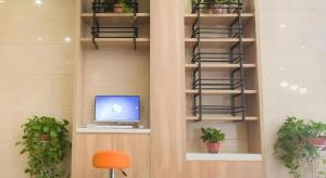 Una habitación con una computadora en un estante con plantas. en Green Tree Inn Express Hefei Yungu Road Linhu Community, en Hefei