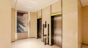 a hallway with a elevator in a building with a painting at City Comfort Inn Jiyuan Jishui Avenue Jigang in Jiyuan +37 photos