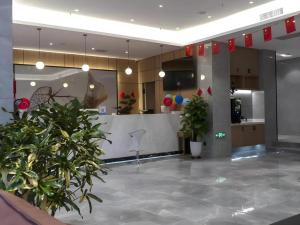 a lobby with potted plants in a building at GreenTree Inn Express Datong High-Speed Railway Station Old City Wall in Datong
