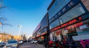 a street with cars parked in front of a building at GreenTree Inn Express Hebei Tangshan Guyan District Xinguang Road in Tangjiazhuang