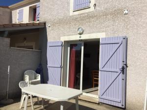 a purple door with a table in front of a building at Les sources de manon in Vallon-Pont-dʼArc