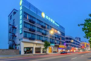 un grand bâtiment dans une rue de la ville la nuit dans l'établissement City Comfort Inn Zhanjiang Central People's Hospital High-speed Railway Station, à Tchia-k'am