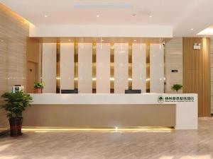 a lobby with a reception desk in a building at Green Tree Inn Express Shandong Dezhou Qihe County Qiqifa in Sangzidian