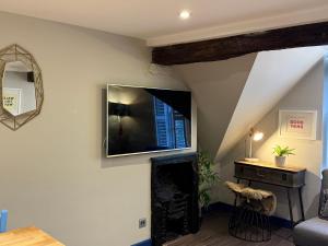 a living room with a fireplace and a tv on the wall at Dream Stays Bath - Kingsmead Street in Bath