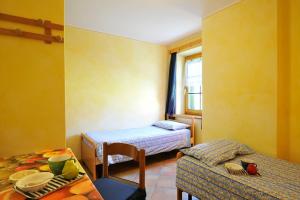 リヴィーニョにあるRododendro - Happy Rentalsのベッド2台とテーブルが備わる小さな客室です。