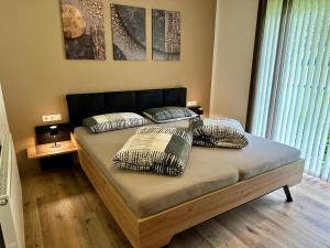 un letto con cuscini sopra in una camera da letto di Apart Kofler a Längenfeld