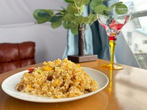 a plate of fried rice on a table with a wine glass at ジーアール柳井 in Yanai