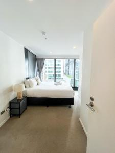 une chambre avec un lit et une grande fenêtre dans l'établissement Chic 2BR City Central Apt w Pool & Sauna & Gym, à Auckland 29 autres photos