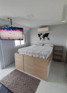 a bedroom with a bed with a cow on the wall at Sol & Sal Flat Alameda in Guarulhos