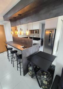 a kitchen with a table and a counter with chairs at Sol & Sal Flat Alameda in Guarulhos